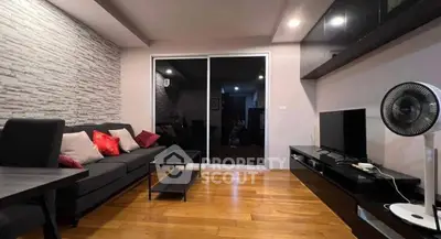 Modern living room with sleek furniture and wooden flooring, featuring a cozy sofa and entertainment unit.