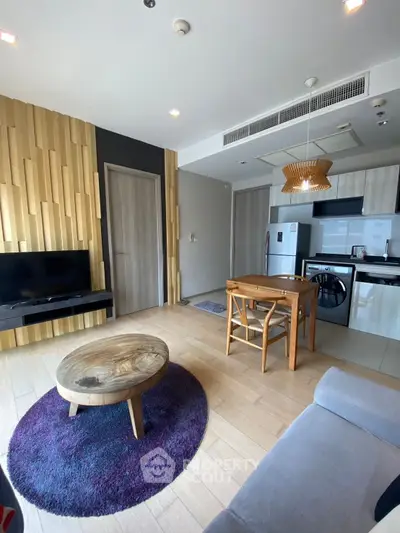 Modern living room with stylish decor and open kitchen layout, featuring wooden accents and cozy furniture.