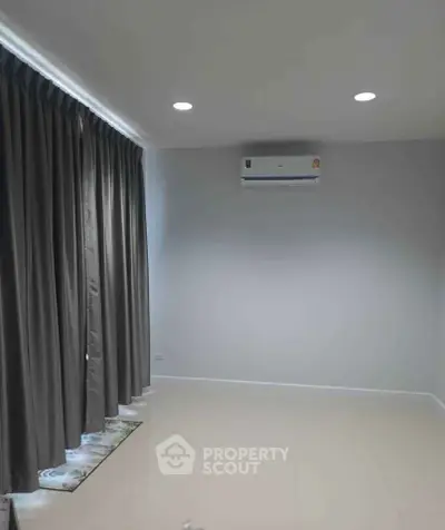 Spacious empty room with air conditioning and elegant curtains, perfect for customization.