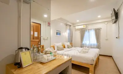 Cozy bedroom with twin beds, modern decor, and natural light, perfect for relaxation.