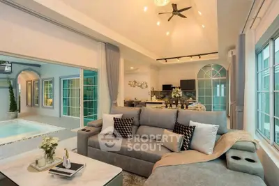 Luxurious living room with pool view and modern open kitchen layout