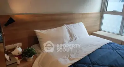 Cozy bedroom with modern decor and large window for natural light.