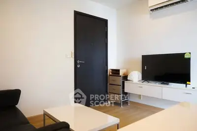 Modern living room with sleek furniture and flat-screen TV, perfect for cozy relaxation.