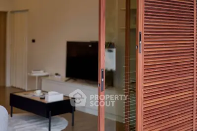 Modern living room with sliding wooden door and sleek TV setup