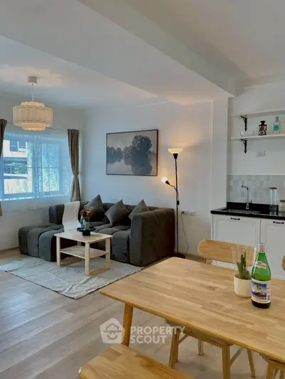 Modern living room with cozy seating and dining area, featuring stylish decor and natural light.