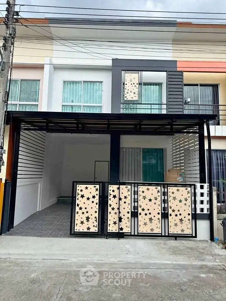 Modern townhouse exterior with stylish facade and gated entrance in a suburban neighborhood.