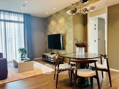 Modern living room with stylish furniture and large window offering natural light.