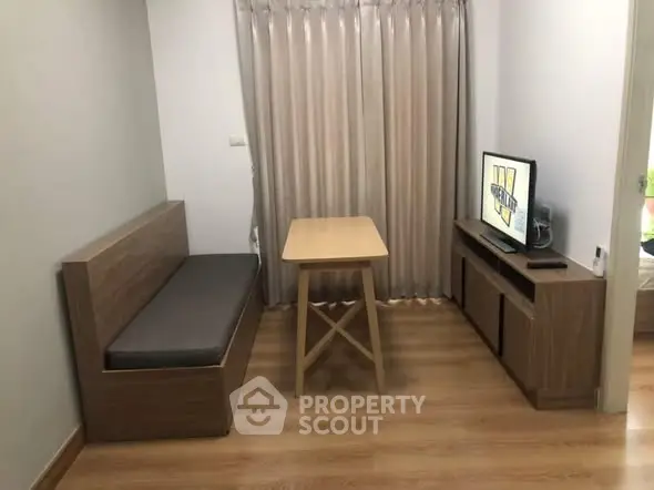 Cozy living room with wooden furniture and TV, perfect for relaxation.