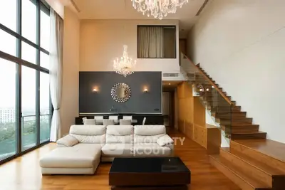Luxurious modern living room with high ceilings, elegant chandeliers, and large windows offering stunning views.