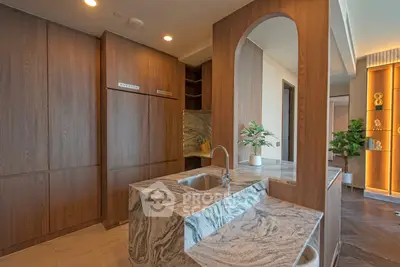 Luxurious modern kitchen with elegant marble countertops and sleek wooden cabinetry.