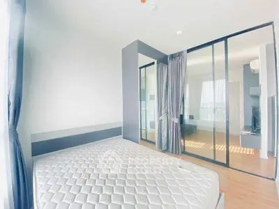 Modern bedroom with large windows and mirrored wardrobe in bright apartment