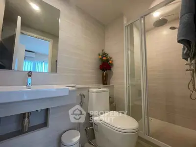 Modern bathroom with sleek fixtures and glass shower enclosure in a stylish apartment.