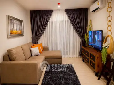 Cozy living room with modern decor, featuring a plush sectional sofa, flat-screen TV, and elegant curtains.