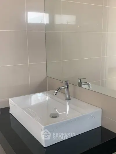 Modern bathroom sink with sleek design and large mirror