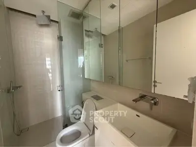 Modern bathroom with glass shower and sleek fixtures in a contemporary apartment.