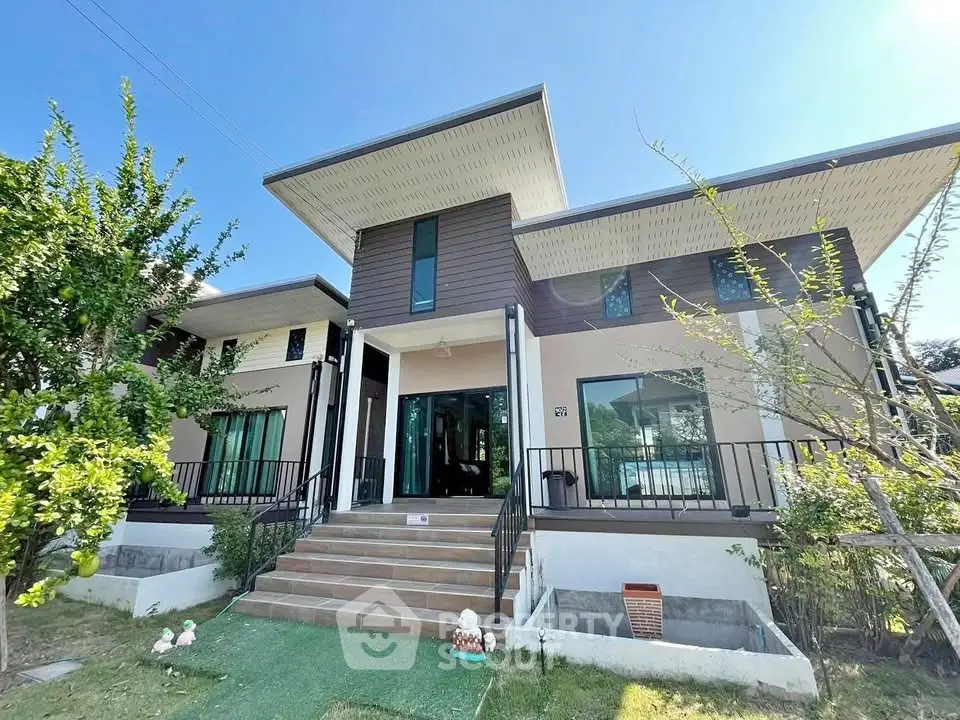 Modern two-story house with large windows and landscaped garden