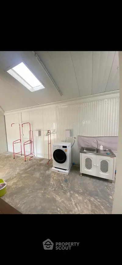 Spacious laundry room with modern washing machine and ample storage space.