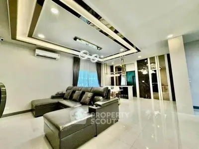 Luxurious modern living room with sleek black leather sofa and stylish ceiling design.
