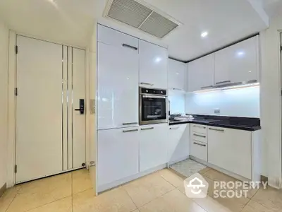 Modern kitchen with sleek white cabinets and built-in oven