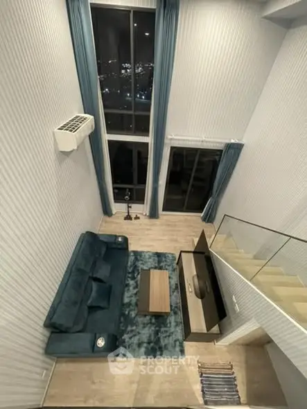 Stunning high-ceiling living room with modern decor and city view, perfect for urban living.