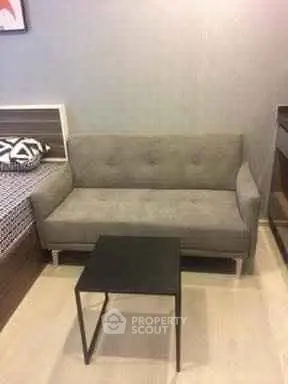 Cozy living room with modern gray sofa and sleek black coffee table.