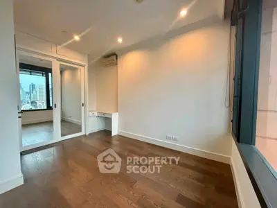 Spacious bedroom with wooden flooring and city view in modern apartment