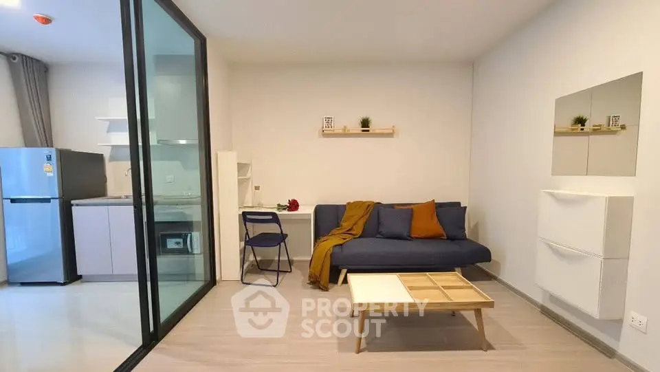 Modern living room with open kitchen, stylish decor, and cozy seating area in a contemporary apartment.