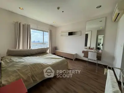 Spacious bedroom with city view, modern furnishings, and ample natural light.