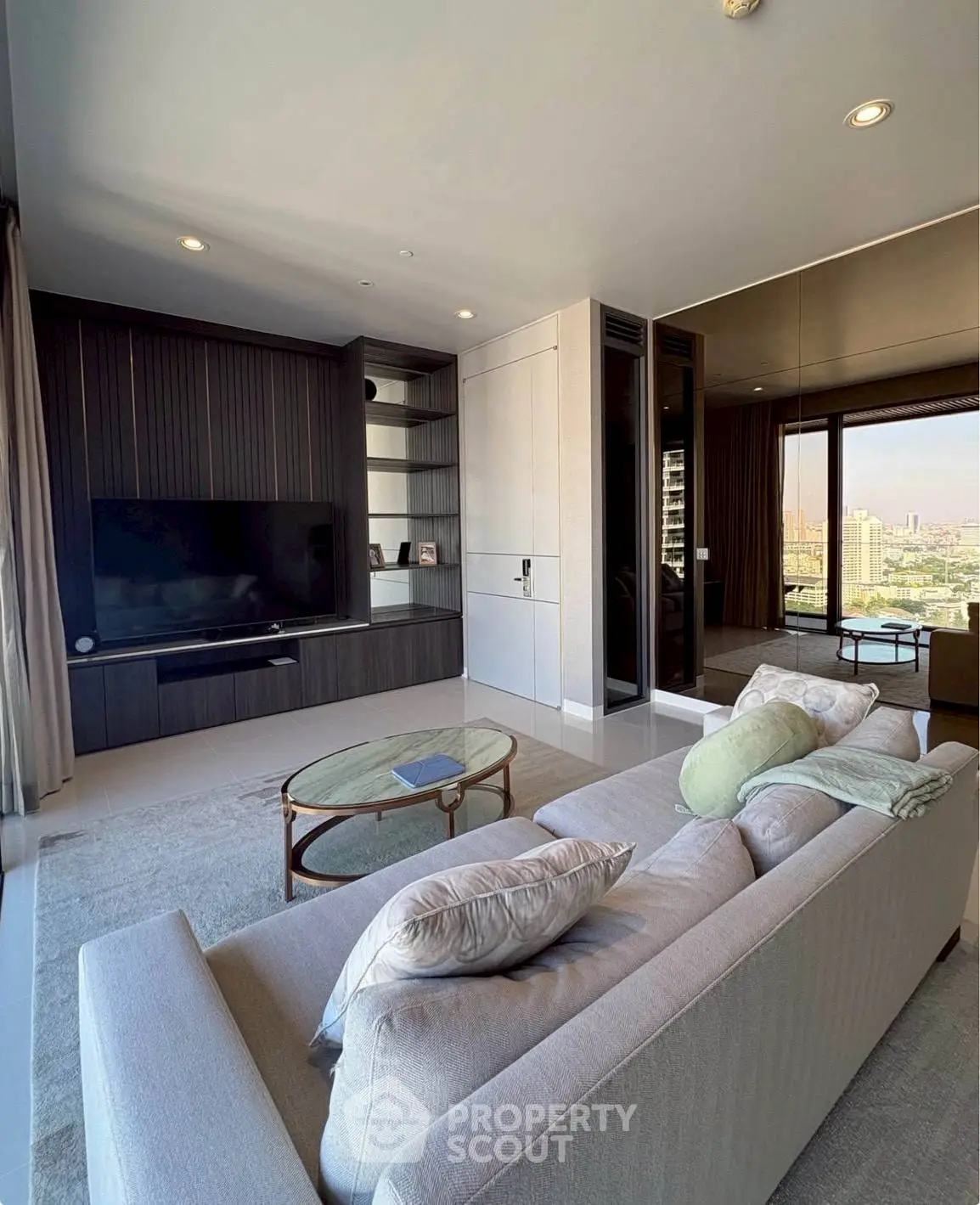 Modern living room with sleek design and city view, featuring a cozy sofa and entertainment center.