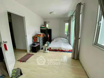 Spacious bedroom with natural light and minimalist decor in modern apartment.