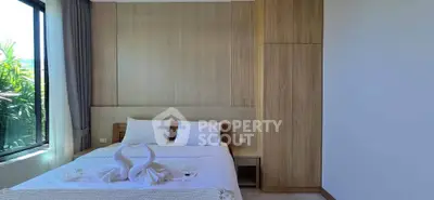 Modern bedroom with wooden accents and large window offering natural light.