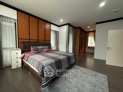 Spacious modern bedroom with stylish decor and ample natural light