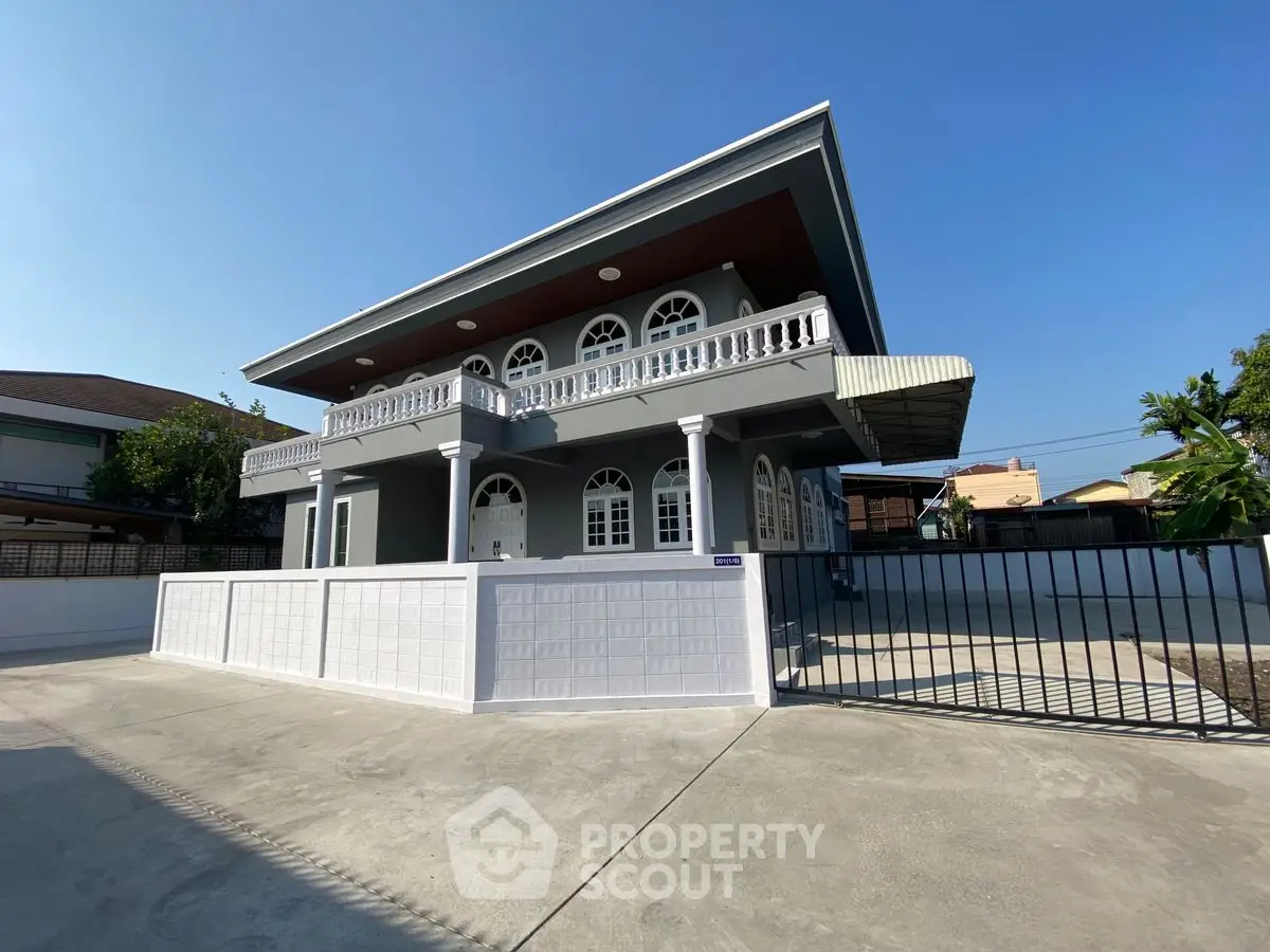 Elegant two-story house with modern design and spacious driveway in sunny neighborhood.