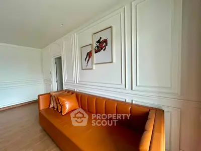 Elegant living room with stylish orange sofa and modern wall art, perfect for contemporary home decor.