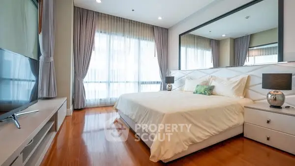 Luxurious bedroom with modern decor and large window for natural light.