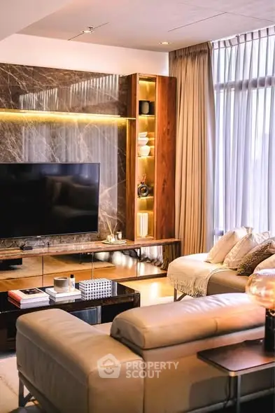 Luxurious living room with modern decor and large TV, perfect for relaxation and entertainment.