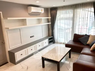 Modern living room with sleek furniture and large windows offering natural light.