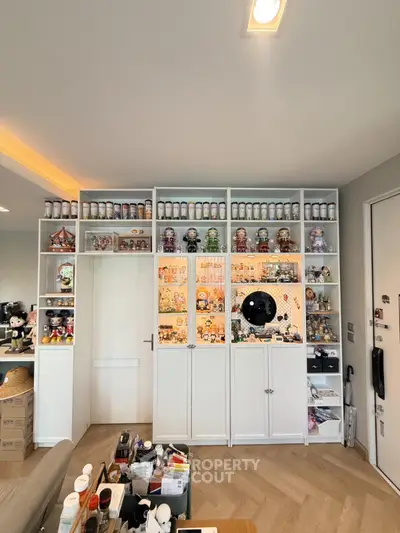 Stylish living room with custom shelving and collectibles display, perfect for showcasing personal treasures.