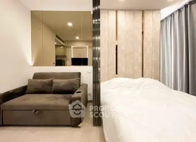 Modern studio apartment with stylish partition, cozy sofa, and elegant bedding, perfect for urban living.