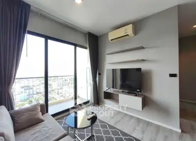 Modern living room with balcony view, featuring sleek furniture and air conditioning.