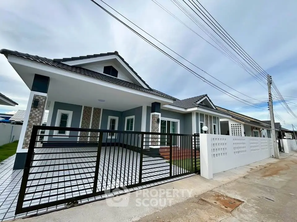Modern single-story house with spacious driveway and stylish exterior design.