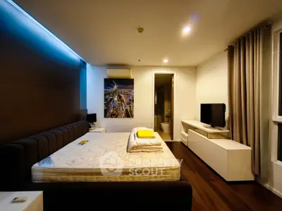 Modern bedroom with stylish decor and ambient lighting, featuring a comfortable bed and sleek furniture.