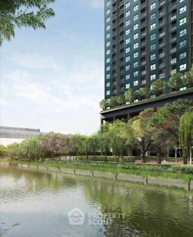 Modern high-rise building with lush greenery by a serene riverside.