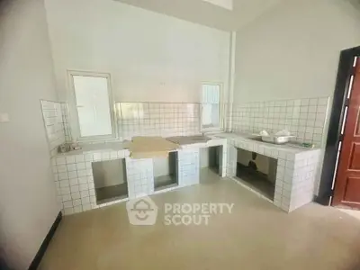 Spacious kitchen with tiled countertops and open layout, perfect for modern living.