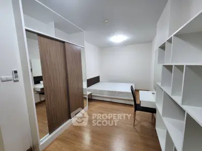 Modern bedroom with wooden flooring, built-in wardrobe, and study desk in a minimalist design.