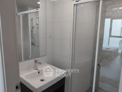 Modern bathroom with sleek shower and stylish sink in contemporary apartment.