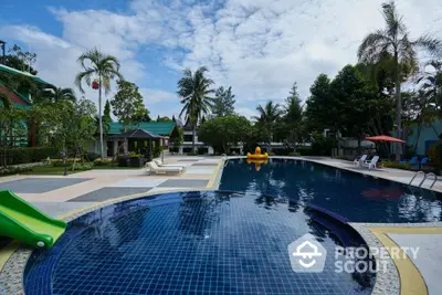 Luxurious outdoor pool area with tropical landscaping and seating, perfect for relaxation and leisure.