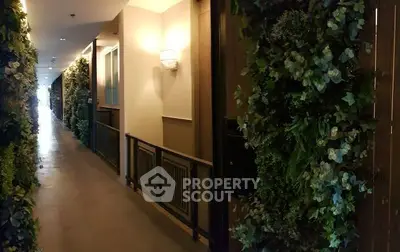 Luxurious corridor with lush greenery and elegant lighting in modern building.