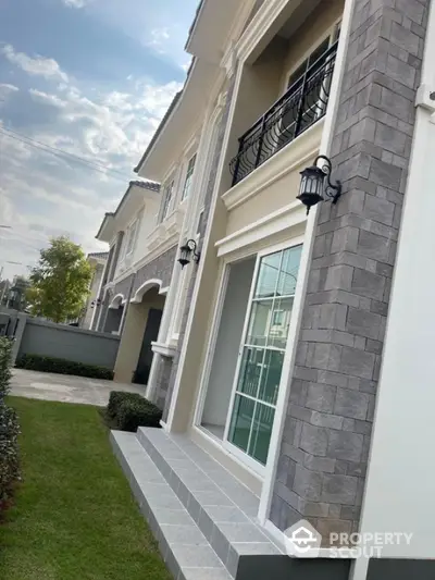 Elegant two-story house with modern facade and lush green lawn