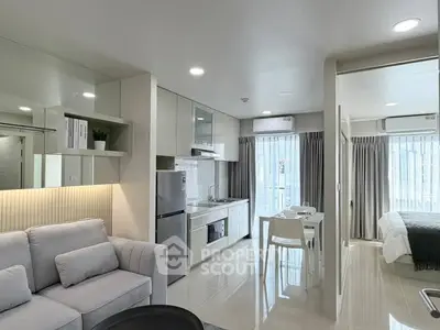 Modern open-plan living room and kitchen with sleek design and natural light